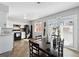 Open kitchen and dining area with modern appliances, white cabinets, and a view to the backyard at 1009 Milky Way, Thornton, CO 80260