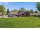 Green backyard with a brick chimney and a swing set at 7359 S Jay St, Littleton, CO 80128