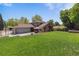 Expansive backyard featuring lush green grass and mature trees at 7359 S Jay St, Littleton, CO 80128
