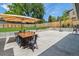Enjoy a spacious backyard featuring a patio with an umbrella-covered dining area, lush lawn, and basketball hoop at 7359 S Jay St, Littleton, CO 80128