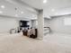 Open basement layout with carpet, white shelving, TV, and couch, ideal for entertainment or relaxing at 7359 S Jay St, Littleton, CO 80128