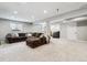Spacious basement featuring neutral colored walls, carpet, and a comfortable couch for relaxing and entertainment at 7359 S Jay St, Littleton, CO 80128