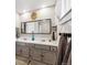 Bathroom featuring double vanity, a large mirror, and geometric patterned walls at 7359 S Jay St, Littleton, CO 80128