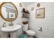 Stylish half bath with white shiplap walls, gold framed mirror, and pedestal sink at 7359 S Jay St, Littleton, CO 80128