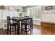 Elegant dining room with stylish wainscoting, rich wood flooring, and a bright window at 7359 S Jay St, Littleton, CO 80128