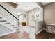Bright foyer with wood floors, staircase, and decorative glass door leading to a sitting room at 7359 S Jay St, Littleton, CO 80128