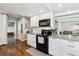 Bright kitchen featuring white cabinets, granite countertops, and stainless steel appliances at 7359 S Jay St, Littleton, CO 80128