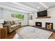 Cozy living room with hardwood floors, a fireplace, and a large window with backyard views at 7359 S Jay St, Littleton, CO 80128