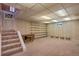 Finished basement with built-in shelving, carpeted stairs, and ample space at 2309 E Floyd Pl, Englewood, CO 80113