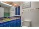 Colorful bathroom featuring blue cabinets, an unique sink, and a large mirror at 2309 E Floyd Pl, Englewood, CO 80113
