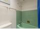 Charming bathroom featuring green tile, a vintage tub, and bright lighting at 2309 E Floyd Pl, Englewood, CO 80113