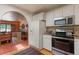 Bright kitchen with white cabinets, stainless steel appliances, and custom tiled backsplash at 2309 E Floyd Pl, Englewood, CO 80113