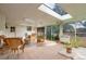 Bright sunroom with brick flooring, skylights, and wicker furniture at 2309 E Floyd Pl, Englewood, CO 80113
