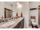Bathroom featuring double sinks, granite countertop, dark wood cabinets, and tile flooring at 2592 Sweet Wind Ave, Castle Rock, CO 80109