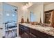 Bathroom featuring double sinks, granite countertop, dark wood cabinets, and tile flooring at 2592 Sweet Wind Ave, Castle Rock, CO 80109