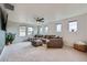 Bright living room with large couch, ceiling fan, and natural light from multiple windows at 2592 Sweet Wind Ave, Castle Rock, CO 80109