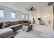 Bright living room with large sectional couch, ceiling fan, and hardwood floors at 2592 Sweet Wind Ave, Castle Rock, CO 80109