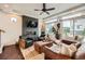 Cozy living room featuring modern decor, fireplace, ceiling fan and large windows at 2592 Sweet Wind Ave, Castle Rock, CO 80109