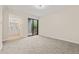 This carpeted bedroom features sliding glass doors that lead to an ensuite bathroom at 3141 S Tamarac Dr # 111G, Denver, CO 80231