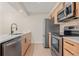 A closer view of the kitchen and its stainless steel appliances and herringbone backsplash at 3141 S Tamarac Dr # 111G, Denver, CO 80231