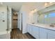 Bright primary bathroom featuring a double sink vanity, walk-in glass shower, and wood-look floors at 14144 Bunny Hop Ln, Parker, CO 80134