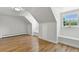 Spacious attic room with hardwood floors, natural light, and built-in window seats at 3884 S Niagara Way, Denver, CO 80237