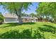 Large backyard with mature trees, manicured lawn, and a view of the home's exterior at 3884 S Niagara Way, Denver, CO 80237
