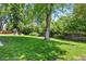 Expansive backyard with lush green grass, mature trees, and ample space for outdoor activities at 3884 S Niagara Way, Denver, CO 80237