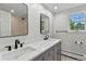Modern bathroom with double vanity, sleek faucets, and natural light from the window at 3884 S Niagara Way, Denver, CO 80237