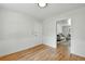 Clean and bright room with hardwood floors, white wainscoting, and direct access to living room at 3884 S Niagara Way, Denver, CO 80237