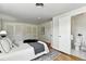 Bright bedroom featuring wood floors, white walls, and a convenient ensuite bathroom at 3884 S Niagara Way, Denver, CO 80237