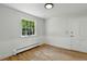 Bright bedroom featuring hardwood floors, wainscoting, and a large window offering natural light at 3884 S Niagara Way, Denver, CO 80237
