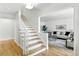 Bright entryway featuring hardwood floors, a staircase, and a glimpse into the living room at 3884 S Niagara Way, Denver, CO 80237