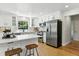 Bright kitchen with white cabinets, stainless steel appliances, hardwood floors, and a center island at 3884 S Niagara Way, Denver, CO 80237