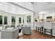 Open concept living area featuring a breakfast bar, tile flooring, white cabinets and light filled windows at 3884 S Niagara Way, Denver, CO 80237