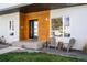 Inviting front entrance with a wood accent wall, stylish seating, and well-maintained landscaping at 1265 Niagara St, Denver, CO 80220
