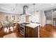 Open concept kitchen with stainless steel hood vent, an island with seating, and an adjacent dining area at 1265 Niagara St, Denver, CO 80220