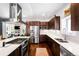 Modern kitchen featuring stainless steel appliances, dark wood cabinets, and a white countertop island at 1265 Niagara St, Denver, CO 80220
