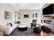 Contemporary living room featuring a white sectional, modern fireplace, and dark armchairs at 1265 Niagara St, Denver, CO 80220
