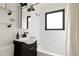 Bright bathroom with walk in shower, black hardware, and white tile at 1411 S Beach Ct, Denver, CO 80219