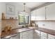 Bright kitchen features granite countertops, stainless steel appliances, white cabinets, and a window at 1411 S Beach Ct, Denver, CO 80219