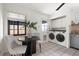 Well-lit laundry room with modern appliances, neutral tile, and dining nook at 1411 S Beach Ct, Denver, CO 80219