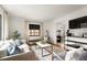 Open-concept living room with neutral decor, hardwood floors, and a view into the dining area at 1411 S Beach Ct, Denver, CO 80219