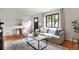 Bright living room features hardwood floors, modern decor, and a large window at 1411 S Beach Ct, Denver, CO 80219