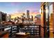 Condo balcony boasting city views with brick surround, and dark metal railing at dusk at 930 Acoma St # 420, Denver, CO 80204