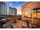 Condo balcony with glass table, seating, and sun shade overlooking neighborhood at dusk at 930 Acoma St # 420, Denver, CO 80204