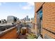 Condo balcony boasting city views with brick surround, and dark metal railing at 930 Acoma St # 420, Denver, CO 80204