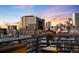 Condo balcony boasting city views with brick surround, and dark metal railing at dusk at 930 Acoma St # 420, Denver, CO 80204