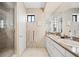 Bright bathroom featuring a double sink vanity, neutral tile, and a glass enclosed walk-in shower at 930 Acoma St # 420, Denver, CO 80204