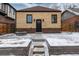 A brick house with a new door and an outdoor fire pit in the snow-covered backyard at 475 S Race St, Denver, CO 80209